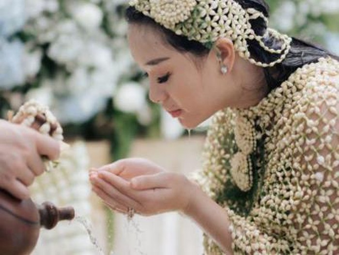 Menjalani rangkaian prosesi 7 bulanan, Zaskia Gotik mengenakan roncean bunga melati dan menadahi air yang mengalir dari kendi. (Foto: Instagram @frrdnnn)