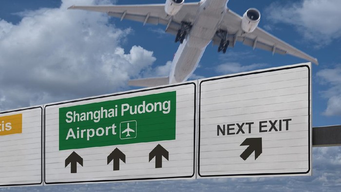 Road sign indicating the direction of Shanghai Pudong airport and a plane that just got up.