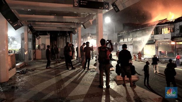 Petugas memadamkan api yang terbakar di depan Bioskop Grand Theater, Senen, (8/10) malam. Kerusuhan di Jakarta sebagai buntut aksi unjuk rasa menolak UU Cipta Kerja masih tak terkendali dengan adanya pengrusakan sejumlah fasilitas umum seperti halter pospol hingga Bioskop. Kekacauan juga terlihat di kawasan itu, tumpukan batu dan pecahan kaca berserakan di Jalan Kramat Raya. Sebelumnya amukan massa juga membakar pos polisi Senen. Mereka memecahkan kaca-kaca halte TransJakarta Pasar Senen. Sejumlah truk yang tengah terparkir pun tak luput dibakar massa.  (CNBC Indonesia/ Muhammad Sabki)