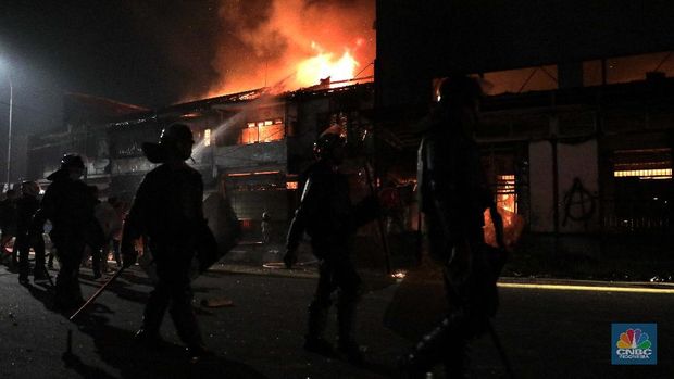 Agents put out a blazing fire in front of the Mulia Agung cinema, Senen, (10/8) the night.  The riots in Jakarta in the wake of the demonstrations against the Job Creation Act were still out of control with the vandalism of various public facilities, such as Pospol's halter for the cinema.  Chaos was also seen in the area, piles of stones and broken glass were scattered over Jalan Kramat Raya.  Previously, the mob also set fire to the Senen police post.  They broke the glass at the TransJakarta Pasar Senen bus stop.  The masses also burned several parked trucks.  (CNBC Indonesia / Muhammad Sabki)