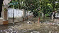 Seorang anak bermain di tengah banjir.