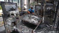 Petugas membersihkan Halte Trans Jakarta Tosari yang dibakar massa pendemo, Jumat (9/10/2020).