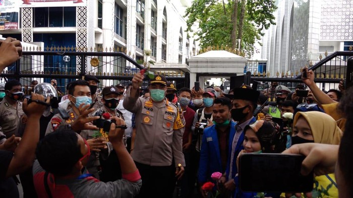 Mahasiswa bagi-bagi mawar ke polisi yang berjaga di depan DPRD Sumut (Datuk Haris-detikcom)