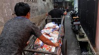 Dengan menggunakan gerobak mereka saling bahu membahu memasuki gang-gang hingga sampai ke rumah warga.
