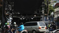 Pengendara melintas di samping Pospol yang ludes terbakar.