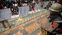 Polisi tampak berjaga di samping kawat berduri saat unjuk rasa menolak Omnibus Law Undang Undang (UU) Cipta Kerja di Kantor DPRD Brebes, Jawa Tengah.