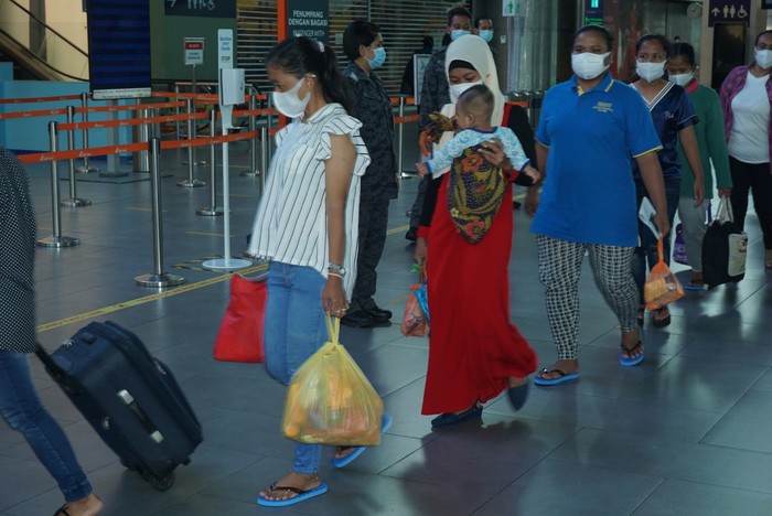 Sejumlah Pekerja Migran Indonesia (PMI) ilegal dalam proses pemulangan,  di Kuala Lumpur International Airport (KLIA) 2 dengan dikawal petugas Imigrasi Malaysia dan pejabat KBRI Kuala Lumpur, Sabtu (10/10/2020). Sebanyak 500 pekerja dipulangkan dengan tujuan Surabaya, Jakarta dan Medan karena masa tahanannya sudah habis. ANTARA Foto/Agus Setiawan/hp.