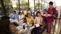 eorang pramugari menyajikan makanan di restoran bertema penerbangan di kantor pusat Thai Airways di Bangkok, Thailand.