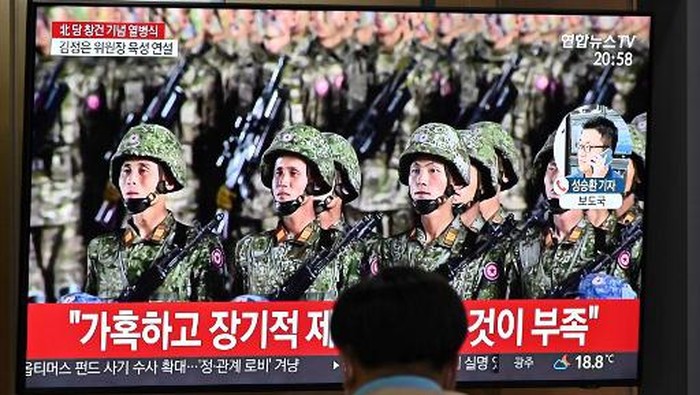 A man watches a television news broadcast of a military parade commemorating the 75th anniversary of North Koreas ruling Workers Party held in Pyongyang, at a railway station in Seoul on October 10, 2020. - Nuclear-armed North Korea held a giant military parade on October 10, television images showed, with thousands of maskless troops defying the coronavirus threat and Pyongyang expected to put on show its latest and most advanced weapons. (Photo by Jung Yeon-je / AFP)