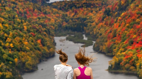 Dua orang wisatawan menikmati angin yang bertiup di tepi danau Lower Ausable, Taman Adirondack, New York, Amerika Serikat.