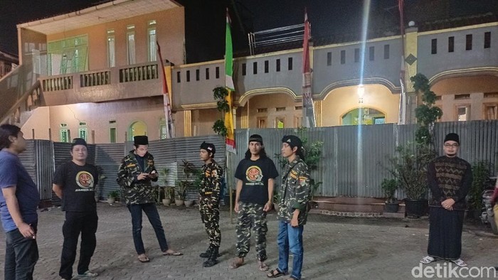 Sejumlah anggota Banser berjaga di pesantren yang dipagari seng ahli waris.