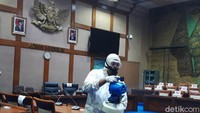 Setiap ruangan disterilisasi oleh satu petugas yang menyemprotkan disinfektan. Petugas tersebut tampak memakai pakaian hazmat lengkap berwarna putih.