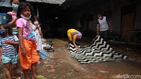 Sebagian warga mencuci tikar menggunakan air yang menggenang.