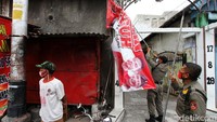 Petugas menurunkan APK salah satu calon peserta Pilkada Solo. 