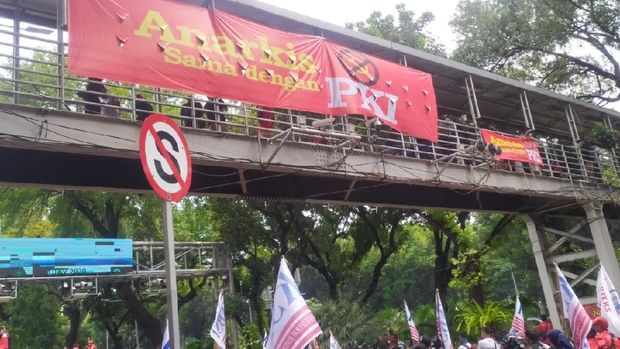 Massa KSBSI memasang spanduk di JPO depan Gedung Sapta Pesona, Jalan Medan Merdeka Barat, Jakarta Pusat, Senin (12/10/1010).