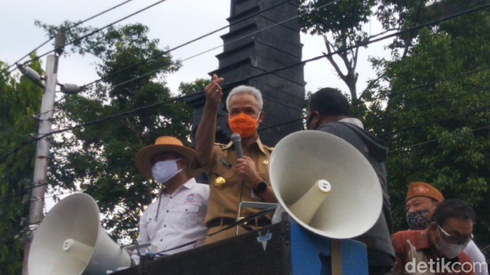 Gubernur Jateng Ganjar Pranowo membagikan love sign ke para pendemo tolak Omnibus Law UU Cipta Kerja, di depan Kantor DPRD Jateng, Semarang, Senin (12/10/2020)