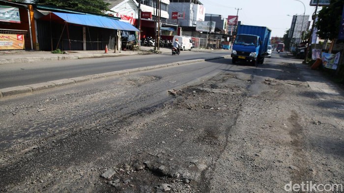 Jalan HM Joyomartono Bekasi Rusak Kendaraan melintasi jalan yang rusak di Jalan HM Joyomartono, Kota Bekasi, Jawa Barat, Senin (12/10/2020). Kondisi jalan rusak di Bekasi itu, sepanjang sekitar 300 meter. Ada sejumlah lubang dengan diameter 10 sampai 20 centimeter. Banyak pula aspal yang telah terkelupas. Kerusakan jalan itu dikeluhkan pengendara disebabkan membuat kemacetan. Kerusakan ini telah terjadi sejak bulan januari 2020 hingga kini tak kunjung diperbaiki.