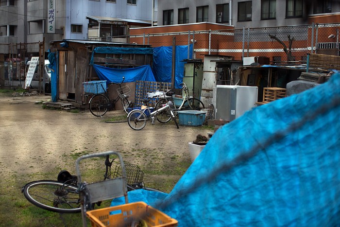 Kamagasaki OSAKA, JAPAN - APRIL 24: A homeless woman pushes a wheelchair past the slum area of Kamagasaki on April 24, 2016 in Osaka, Japan. Kamagasaki, a district in Japan's second largest city Osaka, is home to around 25,000 day labourers, jobless and homeless most of whom start each day hoping for an offer of manual labour and end it queuing for a ticket to access the shelter. (Photo by Carl Court/Getty Images)