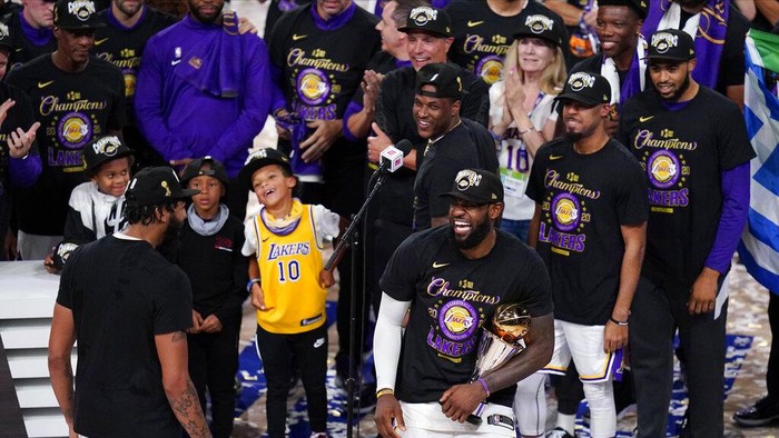 Los Angeles Lakers LeBron James (23) holds the trophy as he celebrates with his teammates after the Lakers defeated the Miami Heat 106-93 in Game 6 of basketballs NBA Finals Sunday, Oct. 11, 2020, in Lake Buena Vista, Fla. (AP Photo/Mark J. Terrill)