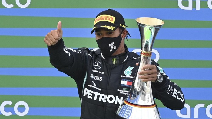 Mercedes driver Lewis Hamilton of Britain holds the trophy at the podium as he celebrates after winning the Eifel Formula One Grand Prix at the Nuerburgring racetrack in Nuerburg, Germany, Sunday, Oct. 11, 2020. (Ina Fassbender, Pool via AP)