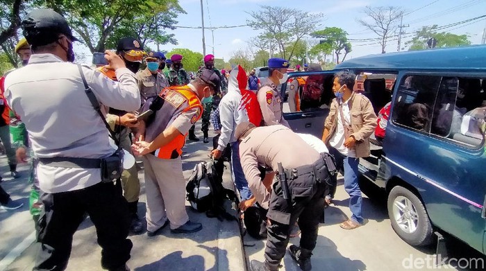 Petugas gabungan menggelar Operasi Yustisi  di Jembatan Suramadu sisi Surabaya. Selain operasi protokol kesehatan (prokes), razia ini juga untuk mengantisipasi aksi kejahatan.