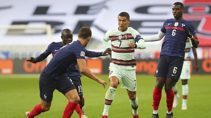 Prancis, Portugal, Portugals Cristiano Ronaldo, center, runs with the ball at Frances Benjamin Pavard, foreground, between Ngolo Kante and Paul Pogba, right, during the UEFA Nations League soccer match between France and Portugal at the Stade de France in Saint-Denis, north of Paris, France, Sunday, Oct. 11, 2020. (AP Photo/Thibault Camus)