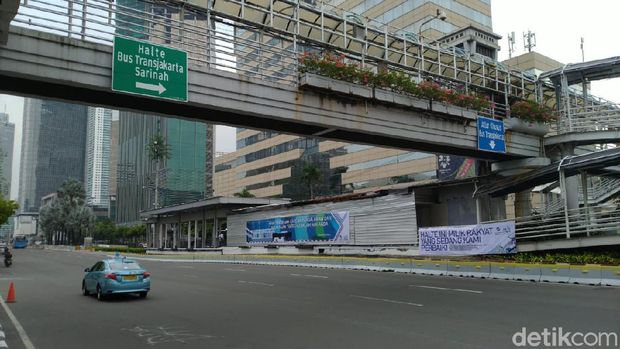 Spanduk yang bertuliskan 'HALTE INI MILIK RAKYAT YANG SEDANG KAMI PERBAIKI' dan 'KAMI BERBENAH KARENA PENGALAMAN DAN PELAYANAN TERBAIK ADALAH HAK ANDA' terpampang di Halte TransJakarta Sarinah, Jalan MH Thamrin, Jakarta Pusat, Senin (12/10/2020).