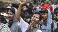 Seorang anak mengepalkan tangannya saat mengikuti aksi tolak UU Cipta Kerja di kawasan Patung Kuda, Jakarta, Selasa (13/10/2020).  