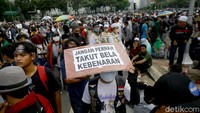 Sejumlah demonstran tampak membawa serta poster yang berisi aspirasi mereka saat ikut serta dalam aksi tolak omnibus law UU Cipta Kerja di kawasan Patung Kuda, Jakarta.
