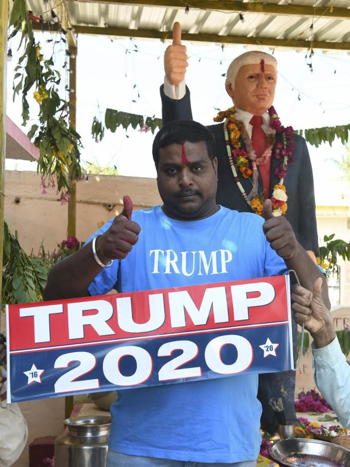 In this photo taken on February 17, 2020, farmer Bussa Krishna, 33, poses with a poster after offering prayers to the statue of US President Donald Trump, at his residence in Jangaon district in Telangana state, some 120 kms from Hyderabad, ahead of the visit of US President Donald Trump to India. - Die-hard Donald Trump fan Bussa Krishna is celebrating the visit of his hero to India next week the only way he knows how -- offering prayers to a life-sized idol of the US President in his home. (Photo by NOAH SEELAM / AFP) / To go with US-INDIA-POLITICS-DIPLOMACY-TRUMP-OFFBEAT