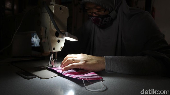 Anif (40) pengrajin masker lurik menjahit masker lurik pesanan pelanggan di industri rumahan Rararere workshop, Patangpuluhan, Wirobrajan, Yogyakarta, Selasa (13/10/2020).