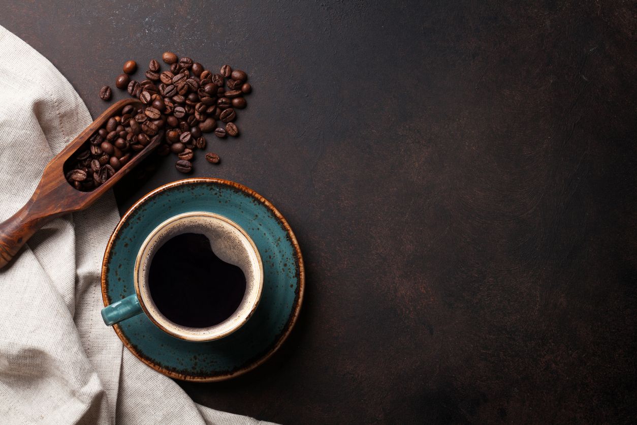 Coffee cup and beans on old kitchen table. Top view with copyspace for your text