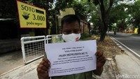 Plt Lurah Kepatihan Kulon bersama petugas babinsa dan linmas memasang pemberitahuan di depan warung Soto Podo Segere, Surakarta, Selasa (13/10/2020).  