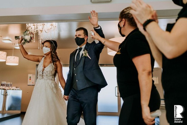 Memakai masker jadi hal wajib bagi pengantin saat menggelar pernikahan. Tapi tetap tak mengurangi momen sakral seperti yang terekam dalam foto karya Valter Antunes dari Portugal. Foto: Reportage Story Award