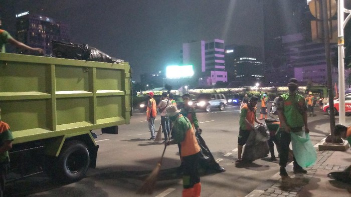 Petugas dari Dinas Lingkungan Hidup Jakarta Pusat membersihkan sisa sampah demonstrasi di Tugu Tani, Jakarta Pusat.
