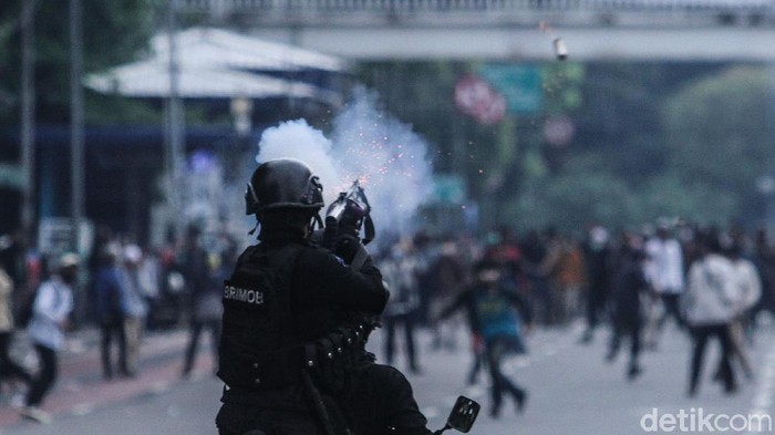 Massa berlarian usai dibubarkan pasukan Brimob dengan menggunakan gas air mata di Gambir, Jakarta, Selasa (13/10/2020).