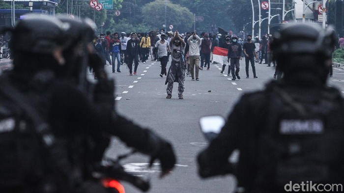 Massa berlarian usai dibubarkan pasukan Brimob dengan menggunakan gas air mata di Gambir, Jakarta, Selasa (13/10/2020).