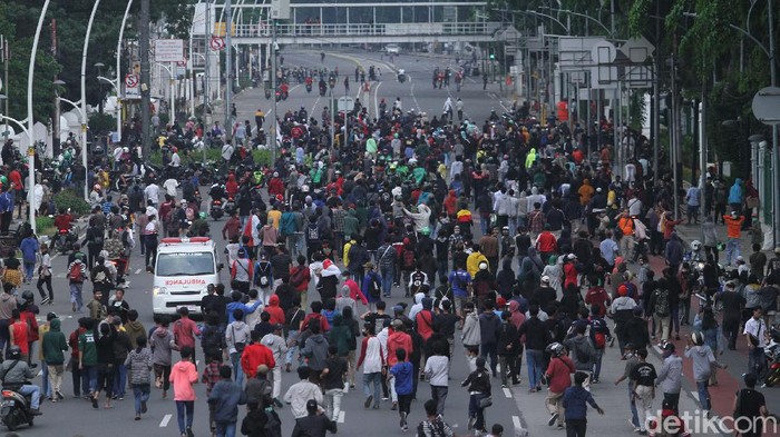 Massa berlarian usai dibubarkan pasukan Brimob dengan menggunakan gas air mata di Gambir, Jakarta, Selasa (13/10/2020).