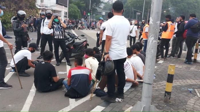 Polisi mengamankan belasan remaja di Tugu Tani yang diduga merusuh saat demo.