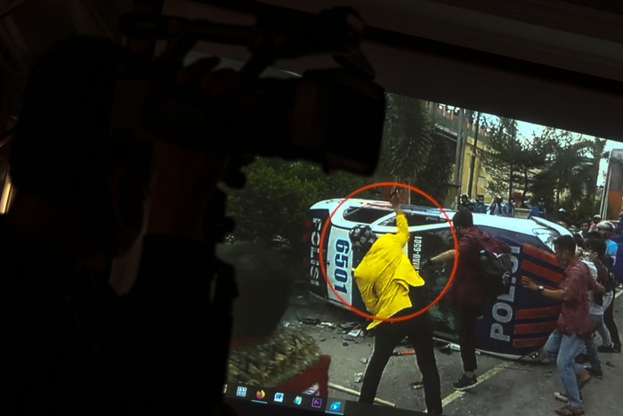 Petugas Kepolisian memperlihatkan rekaman video pengujukrasa yang melakukan pengrusakan kendaraan dinas Kepolisian saat unjukrasa tolak UU Cipta Kerja ketika gelar kasus, di Mapolda Riau, di Pekanbaru, Senin (12/10/2020). Pelaku yang saat berunjukrasa tolak UU Cipta Kerja pada Kamis (8/10/2020) lalu yang mengenakan jas almamater Universitas Lancang Kuning ini ternyata bukan lah seorang mahasiswa, Polisi juga memperlihatkan barang bukti pengrusakan berupa video rekaman, kayu, batu dan botol minuman keras. ANTARA FOTO/Rony Muharrman/hp.