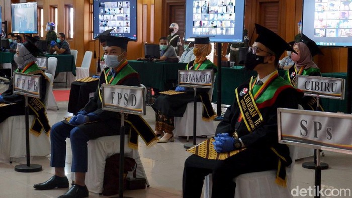Universitas di Bandung menggelar prosesi wisuda tatap muka di tengah pandemi COVID-19. Sejumlah protokol kesehatan pun diterapkan untuk cegah penyebaran Corona.