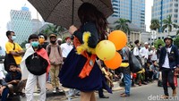 Sosok tersebut tampak membawa balon yang salah satunya bertuliskan PHK, Ga Dapat Sawer. 