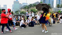 Kehadiran sosok yang membawa payung serta balon berwarna kuning dan oranye menarik perhatian massa aksi tolak omnibus law UU Cipta Kerja di kawasan Patung Kuda, Jakarta, Selasa (13/10/2020).