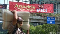 Spanduk tersebut berwarna merah, kuning, hitam, dan putih.