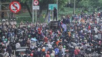 Jalan yang diblokir ini membuat para mahasiswa menggelar aksi orasinya di kolong rel kereta Gambir.  