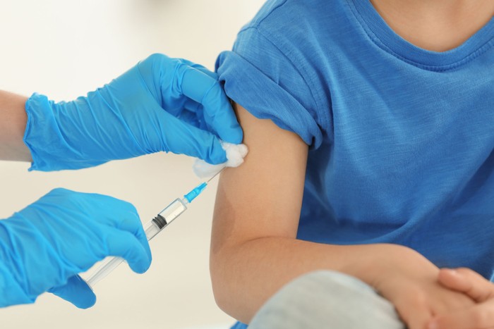 Vaccination concept. Female doctor vaccinating cute little boy i ilustrasi vaksin
