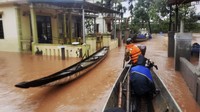 Tim penyelamat menyusuri permukiman yang terendam banjir menggunakan perahu untuk mengevakuasi warga. Ho Cau/VNA via AP.
