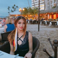 Atasan lace hitam nan seksi menjadi pilihan Clarissa ketika liburan di sebuah pantai. (Foto: Instagram/@clarissatanoe)