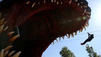 Seorang pengunjung menaiki zipline melalui mulut Godzilla di taman hiburan Nijigen no Mori, Awajishima, Prefektur Hyogo, Jepang.