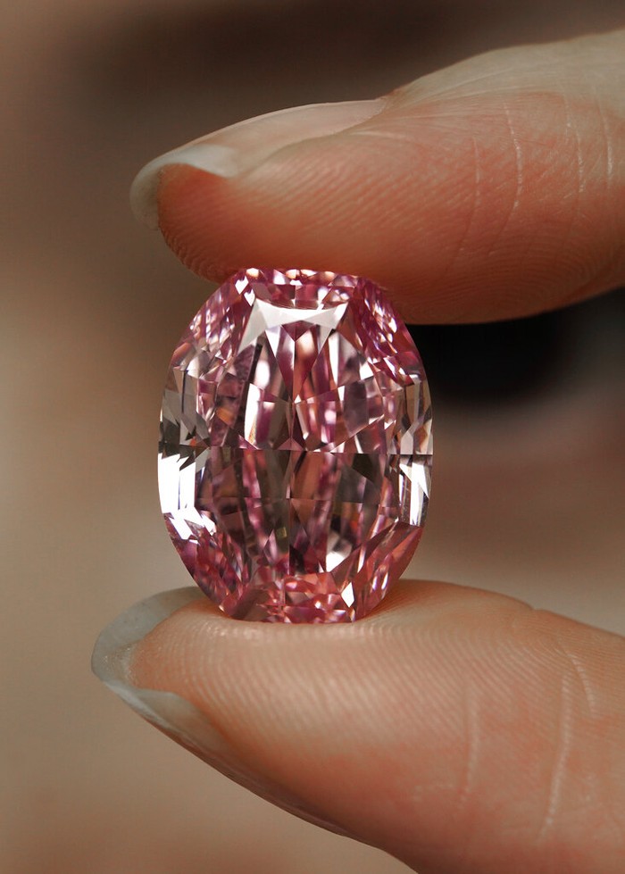 Hong Kong Pink Diamond A model displays an ultra-rare 14.83-carat diamond that is one of the largest internally flawless fancy vivid purple-pink gem ever graded by the Gemological Institute of America at a Sotheby's auction room in Hong Kong Monday, Oct. 12, 2020. The diamond will be offered for sale in Geneva on Nov. 11, 2020. (AP Photo/Vincent Yu)